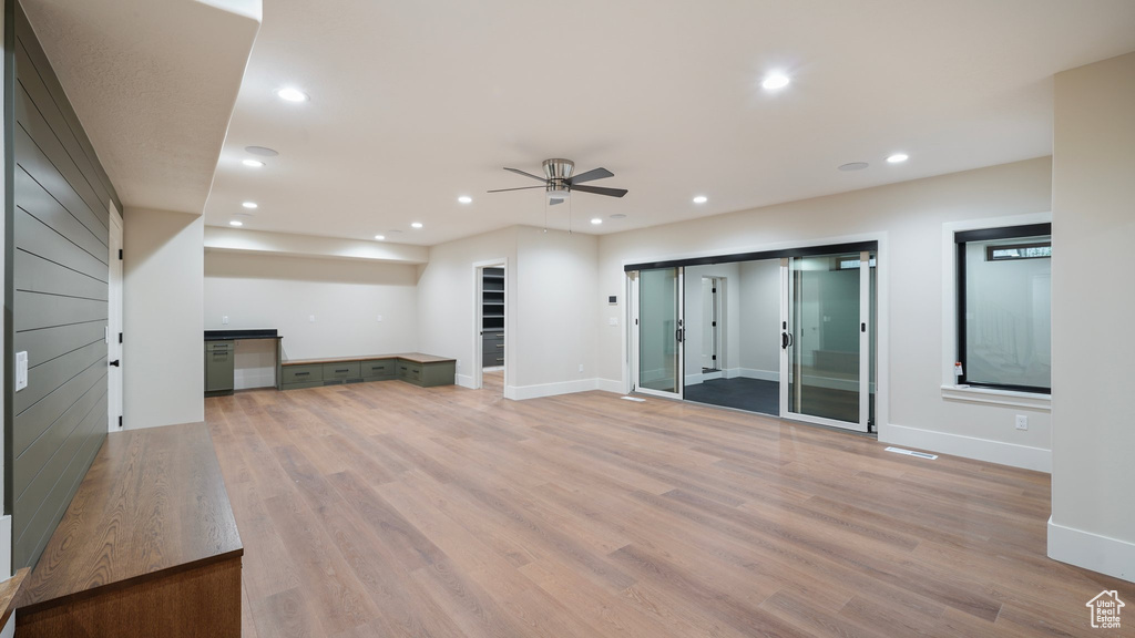 Unfurnished living room with light hardwood / wood-style floors and ceiling fan