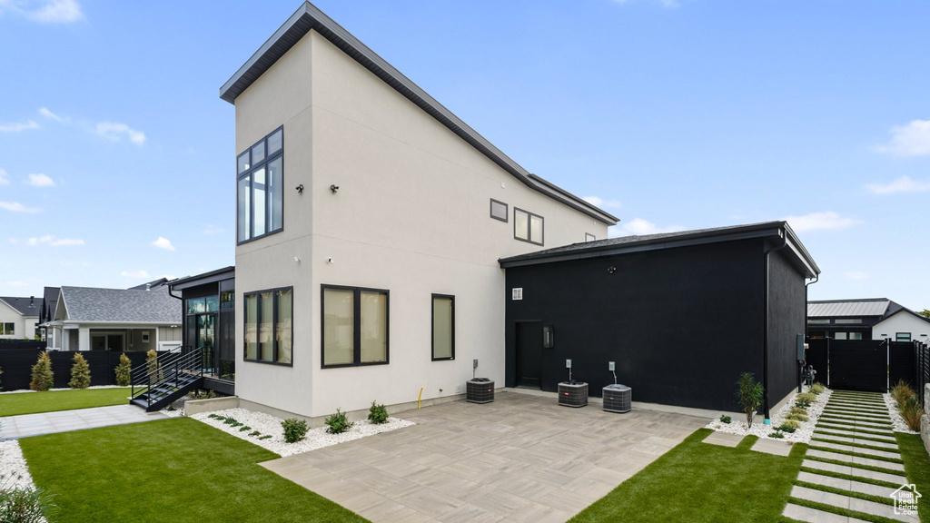 Rear view of house featuring a patio and a lawn