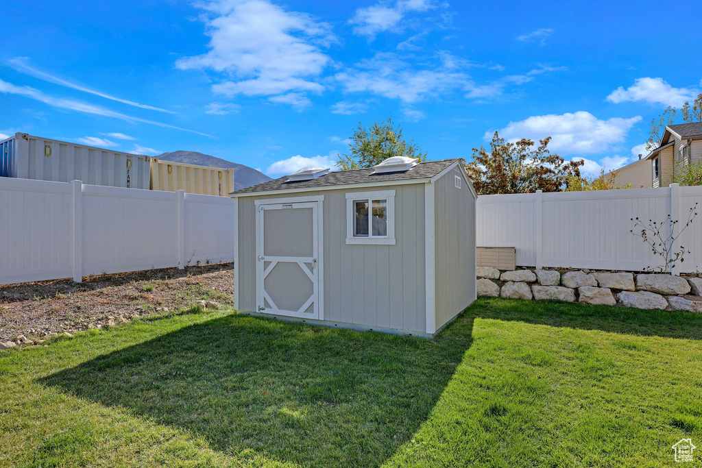 View of outdoor structure with a yard