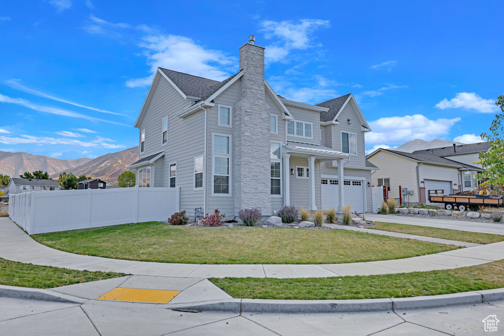 View of front of house featuring a mountain view and a front yard