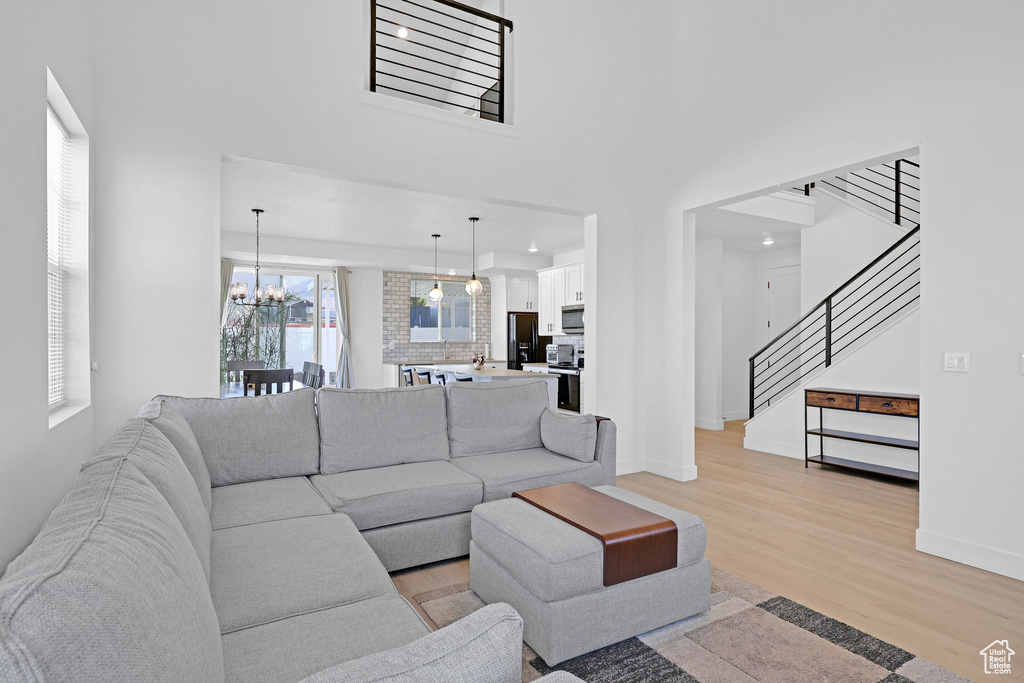 Living room featuring a notable chandelier and light wood-type flooring