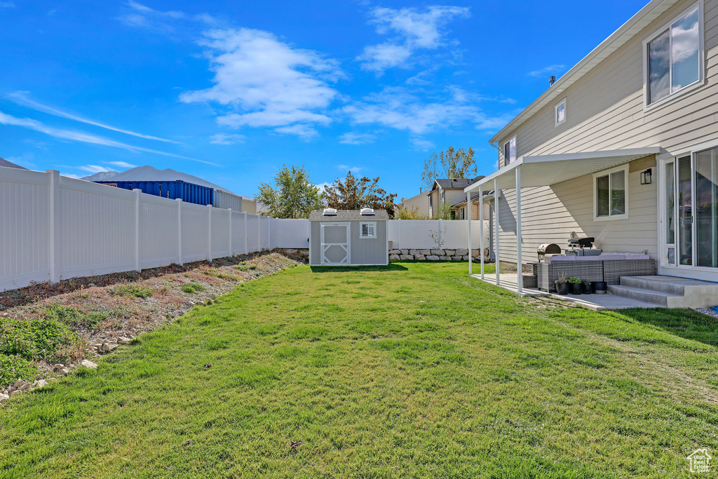 View of yard with a patio and a storage unit