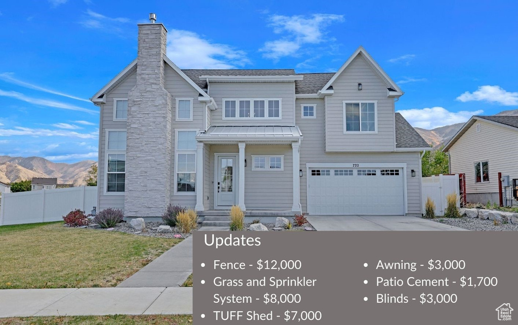 View of front of home featuring a mountain view, a front yard, and a garage