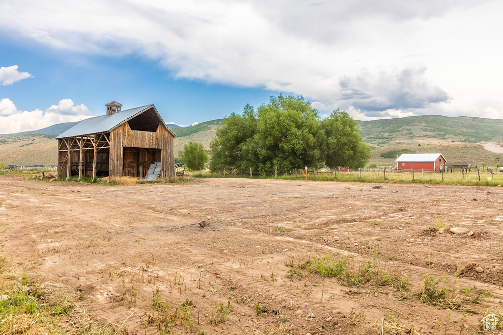 View of yard featuring a rural view, a mountain view, and an outbuilding