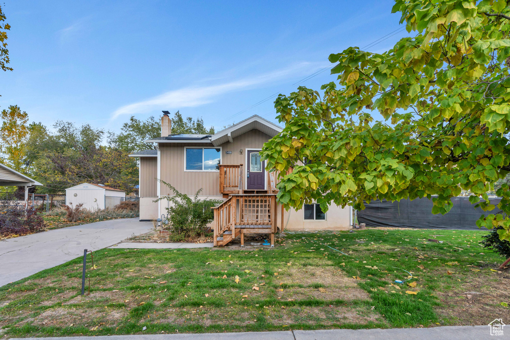 View of front of house featuring a front yard and a shed