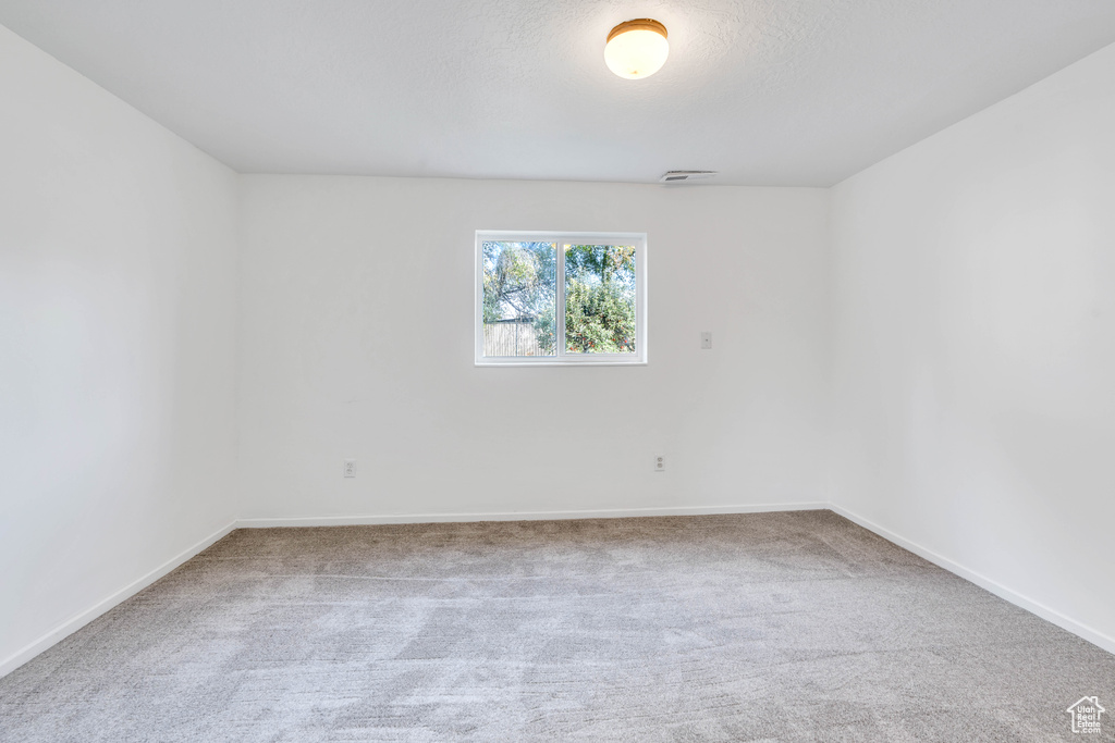 Carpeted spare room featuring a textured ceiling