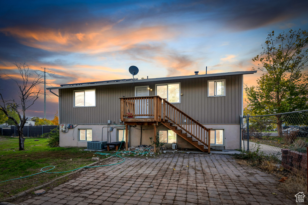 Back house at dusk featuring a yard and a patio area