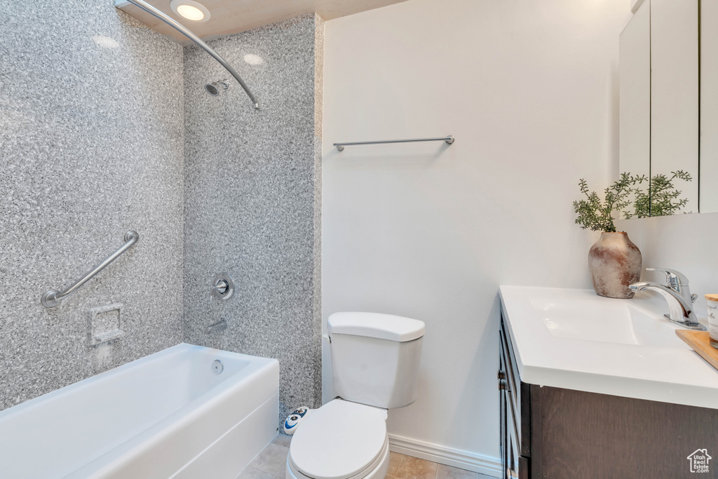 Full bathroom featuring tiled shower / bath, vanity, toilet, and tile patterned floors