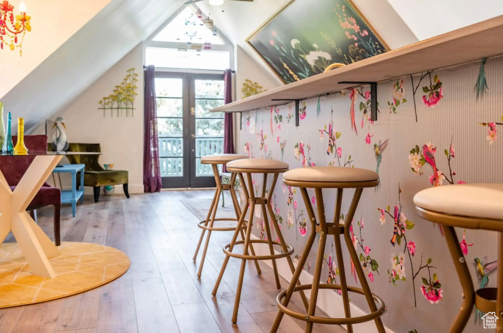 Bar featuring french doors, light hardwood / wood-style floors, and lofted ceiling