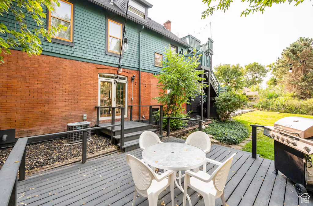 Wooden deck featuring central AC and a grill