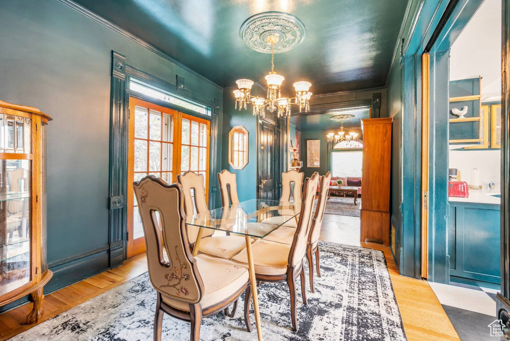 Dining room with ornamental molding, a healthy amount of sunlight, and light wood-type flooring