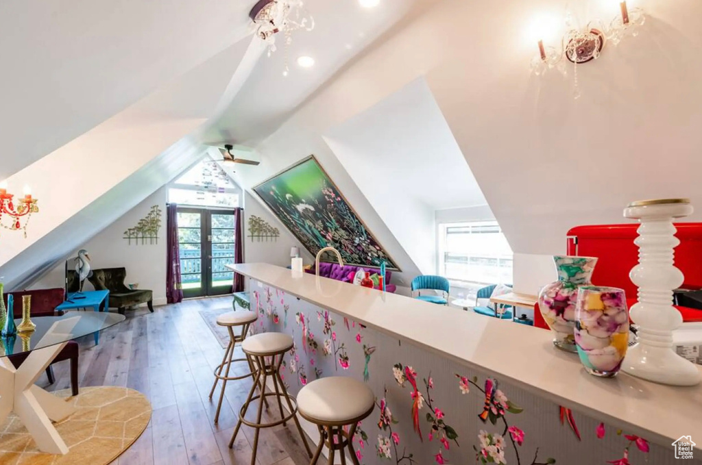 Bar with light hardwood / wood-style flooring, french doors, a healthy amount of sunlight, and lofted ceiling