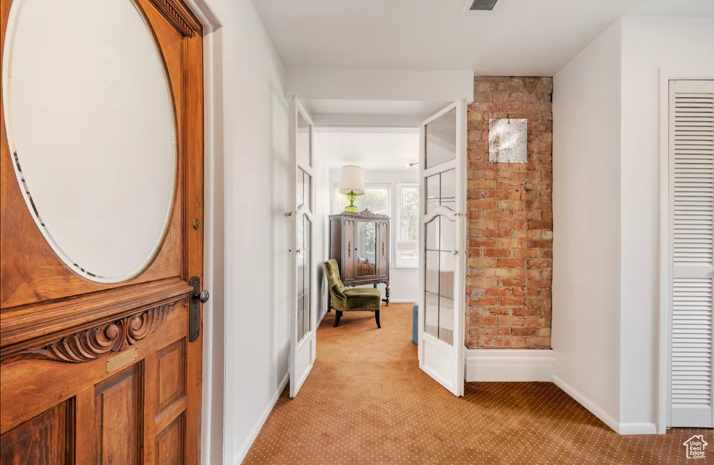 Hall featuring french doors and light carpet