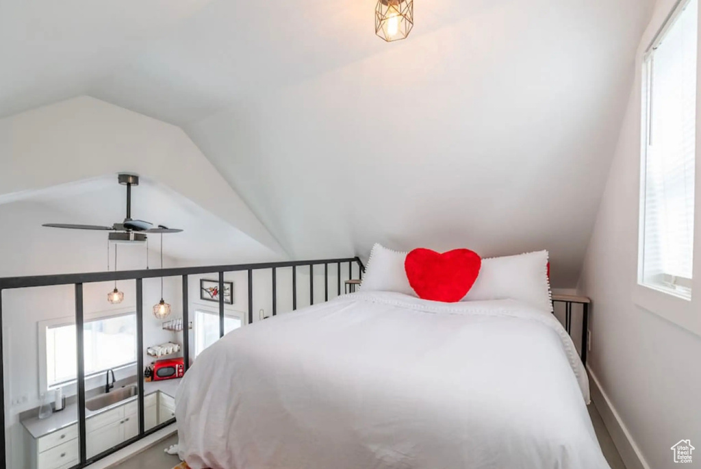 Bedroom featuring multiple windows and vaulted ceiling