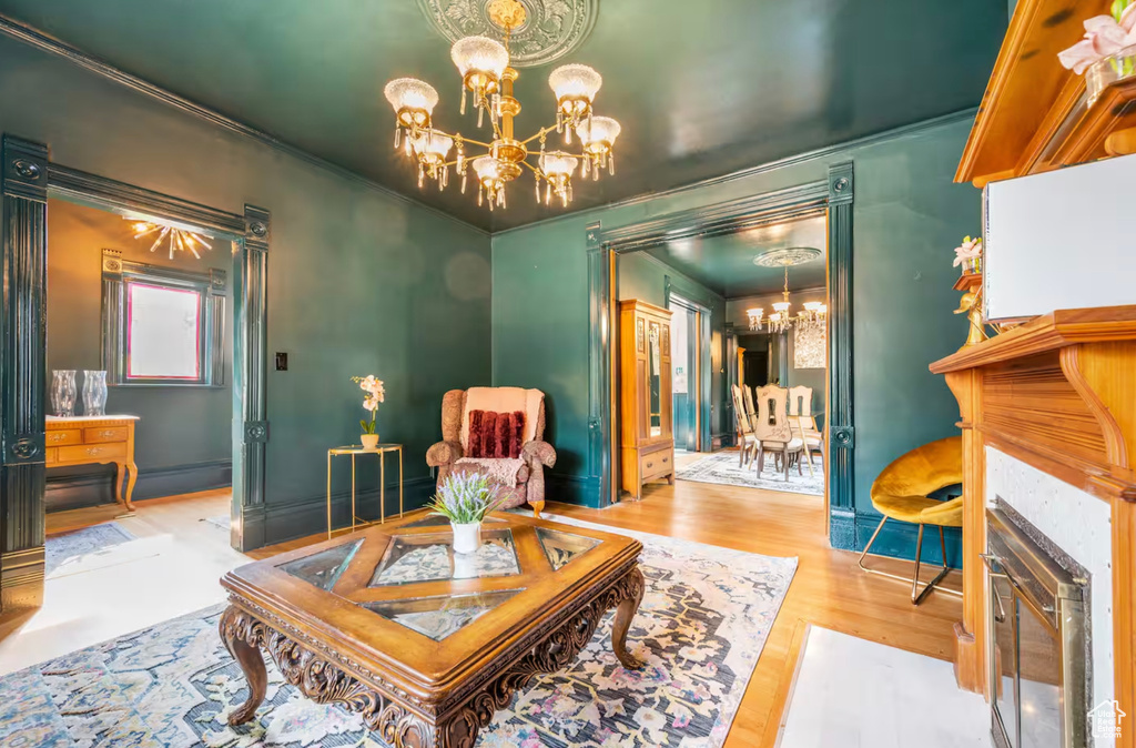 Sitting room featuring ornamental molding, an inviting chandelier, and hardwood / wood-style floors