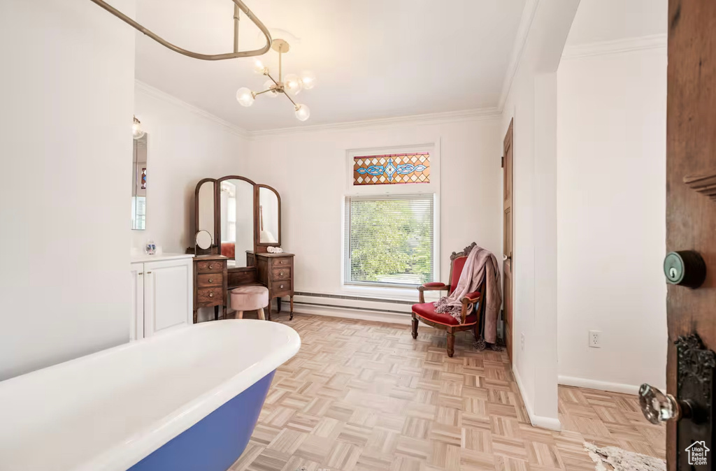 Living area featuring a baseboard radiator, a notable chandelier, ornamental molding, and light parquet flooring