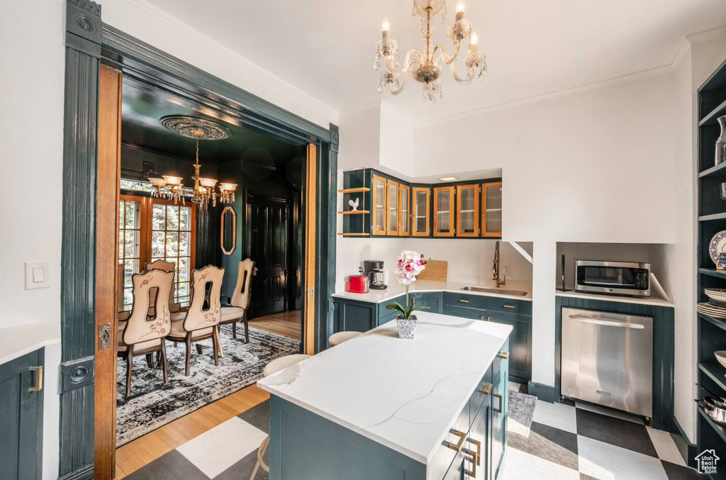 Kitchen featuring a kitchen island, appliances with stainless steel finishes, pendant lighting, and light hardwood / wood-style floors