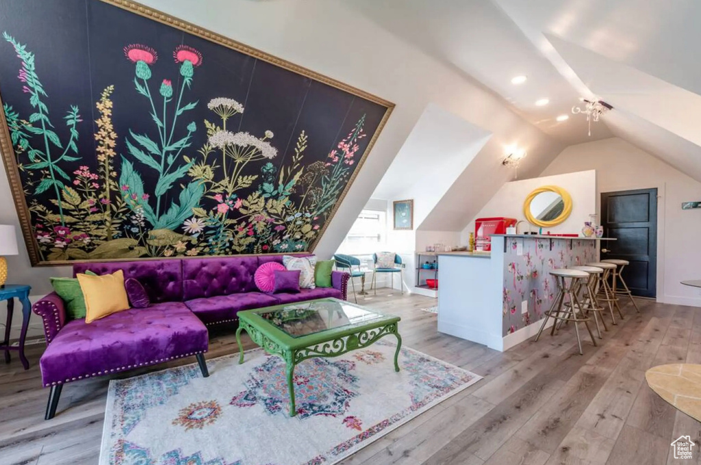 Living room with lofted ceiling and hardwood / wood-style flooring