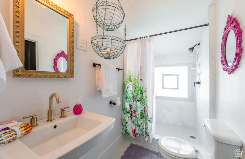 Bathroom with toilet, sink, a shower with shower curtain, and tile patterned flooring