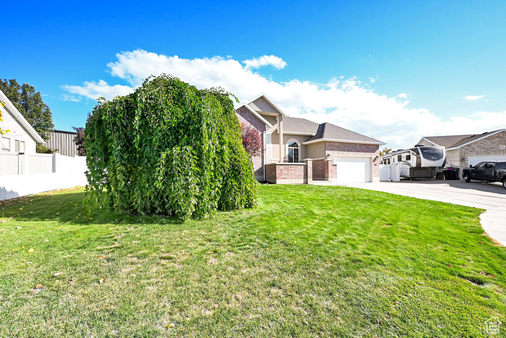 View of front of house featuring a garage and a front lawn