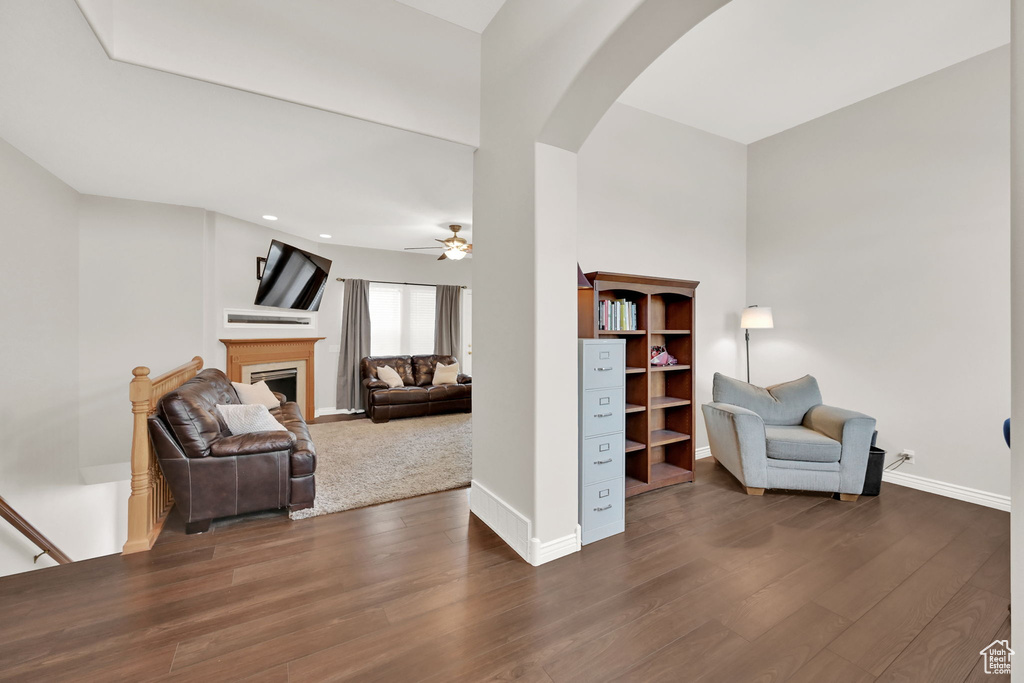 Living area featuring dark wood-type flooring and ceiling fan