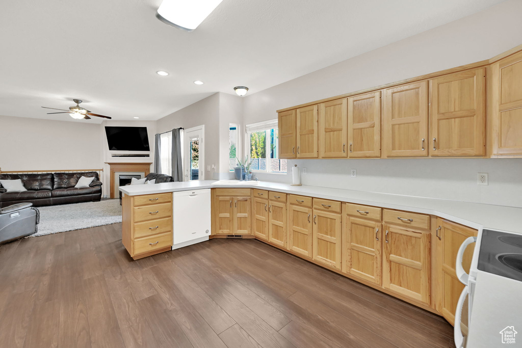 Kitchen with light brown cabinets, hardwood / wood-style floors, kitchen peninsula, ceiling fan, and white appliances