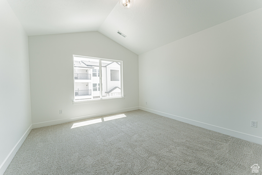Bonus room featuring light colored carpet and vaulted ceiling