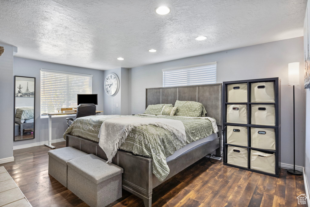 Bedroom featuring a textured ceiling and dark wood-type flooring