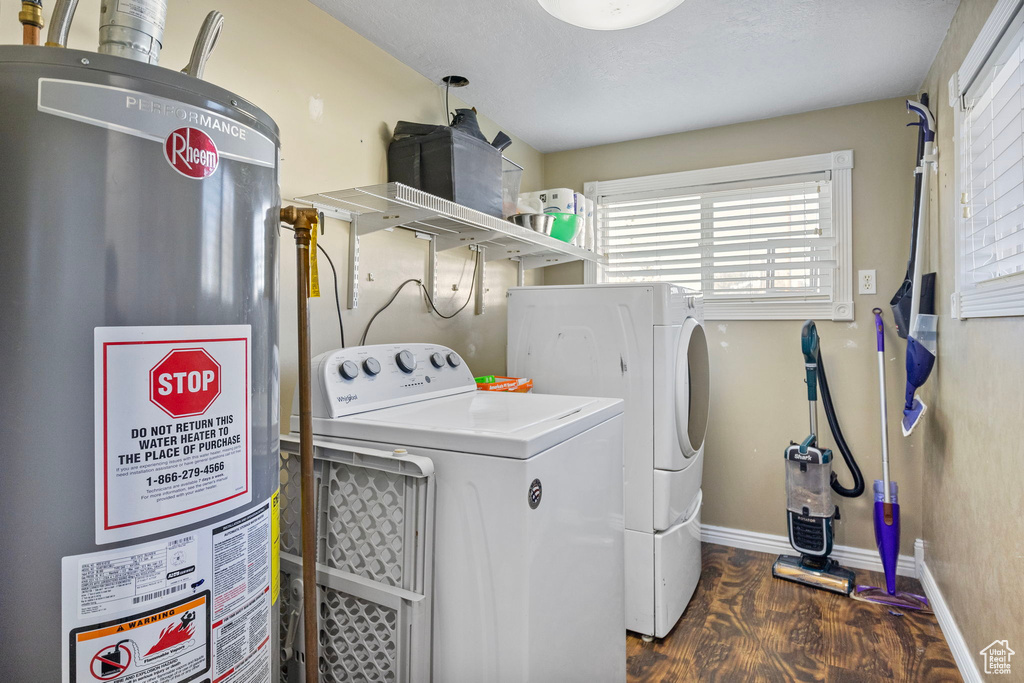 Laundry area with gas water heater, washer and dryer, and dark hardwood / wood-style floors