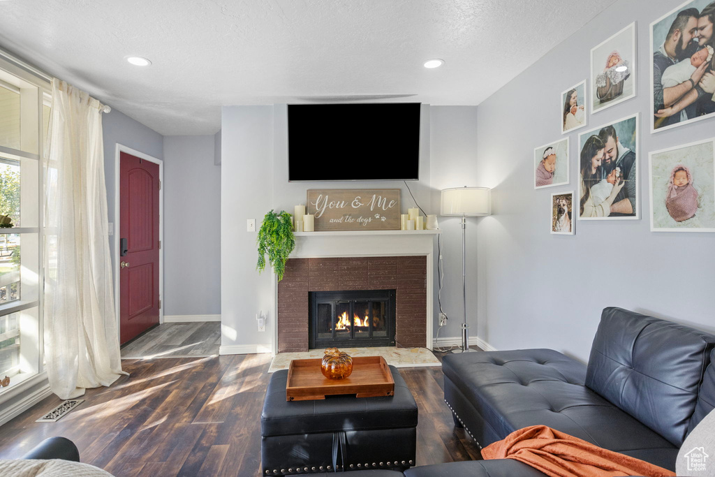 Living room with a textured ceiling and wood-type flooring