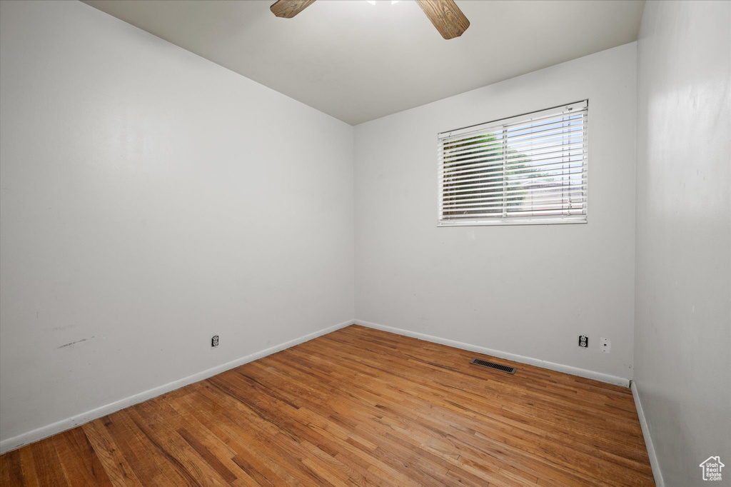 Empty room with wood-type flooring and ceiling fan