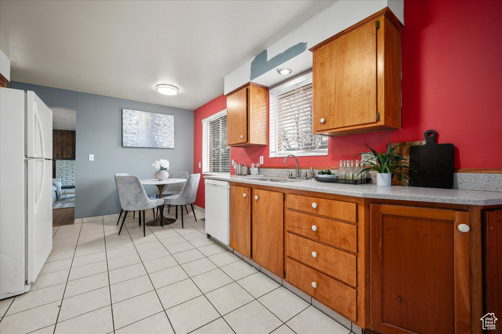 Kitchen featuring white appliances, light tile patterned floors, and sink