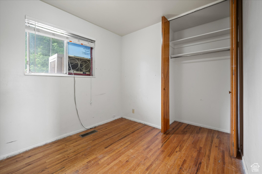 Unfurnished bedroom featuring hardwood / wood-style floors and a closet