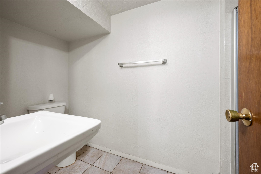 Bathroom with toilet and tile patterned flooring