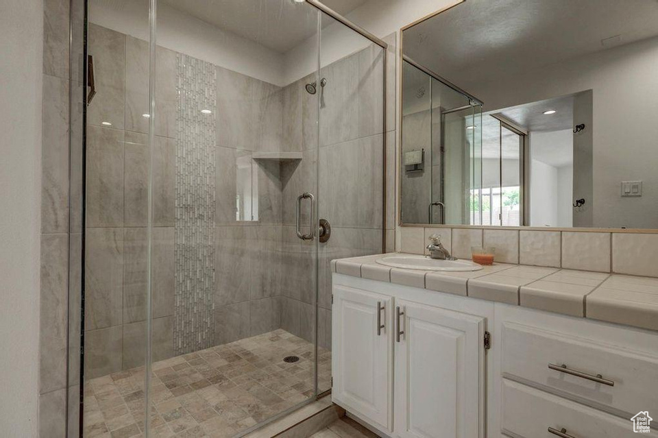 Bathroom with vanity and a shower with shower door