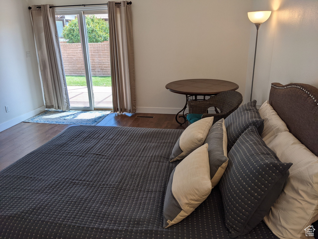 Bedroom with dark hardwood / wood-style floors and access to exterior