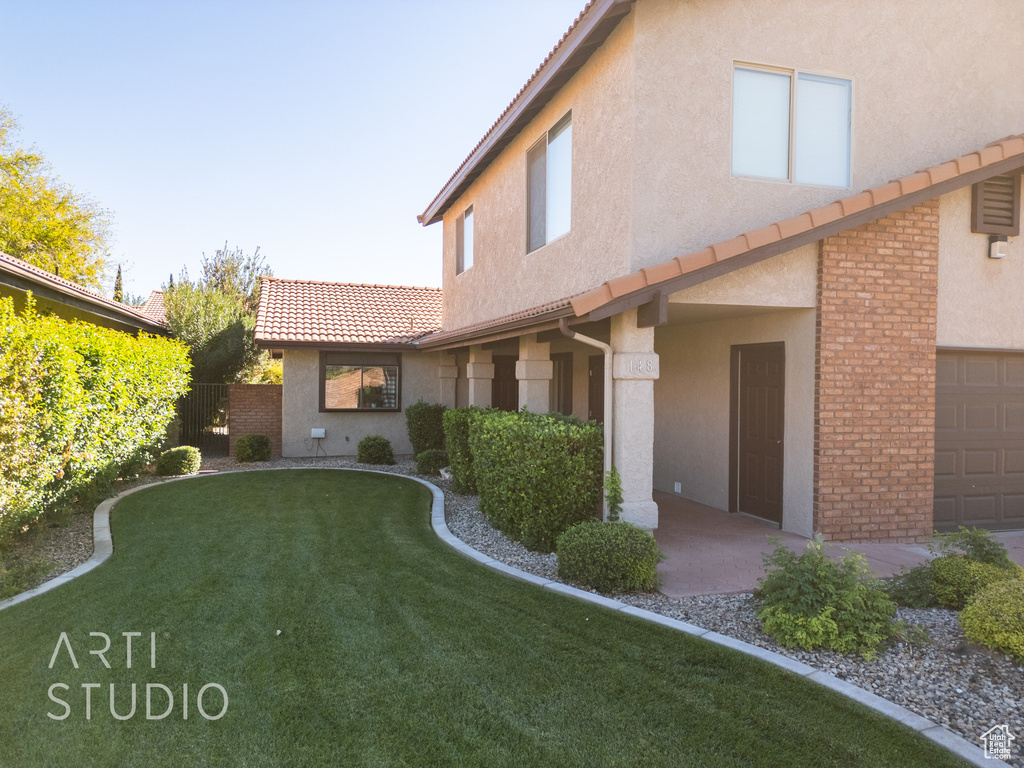 Rear view of property featuring a yard and a garage
