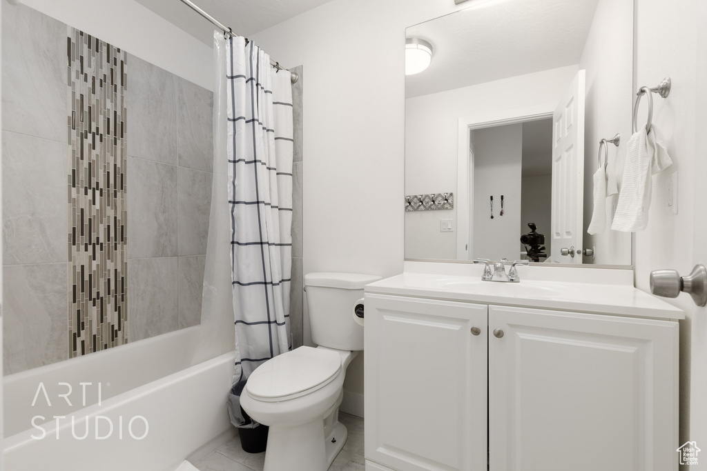 Full bathroom featuring vanity, shower / tub combo with curtain, and toilet