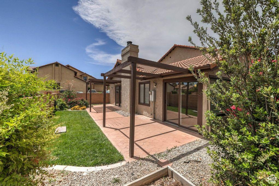 Rear view of house with a patio and a lawn