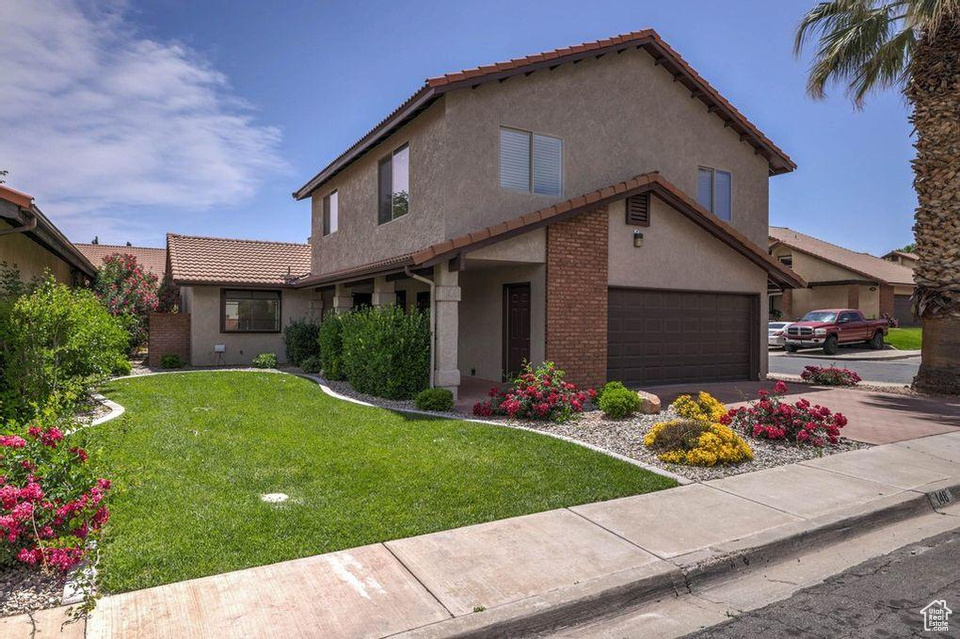 View of front of house with a front lawn and a garage