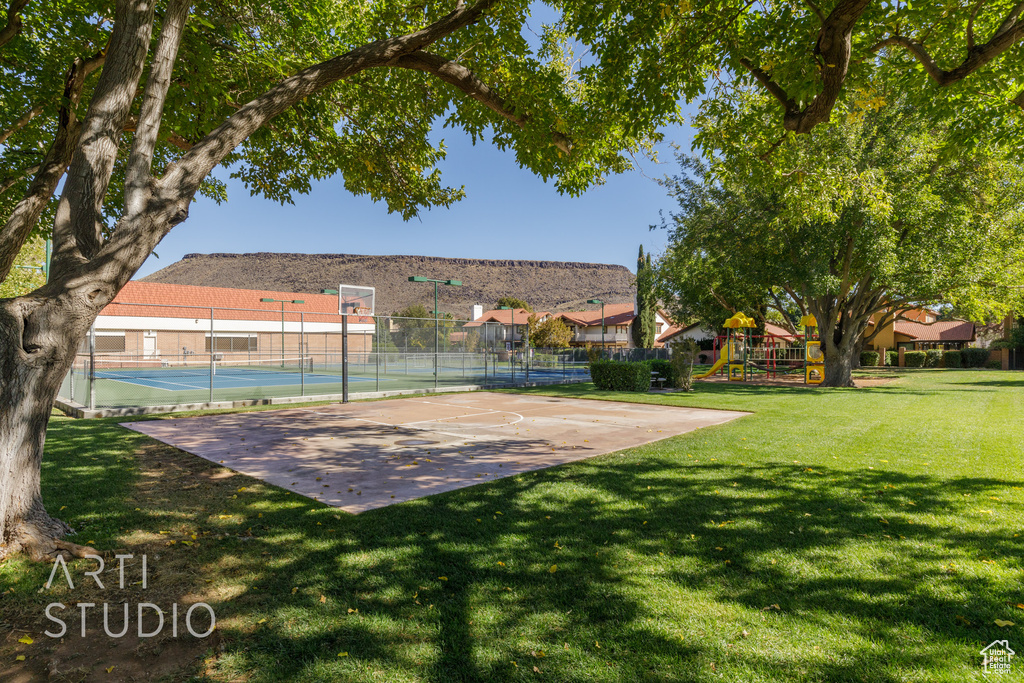 Exterior space featuring a playground, a yard, and basketball hoop