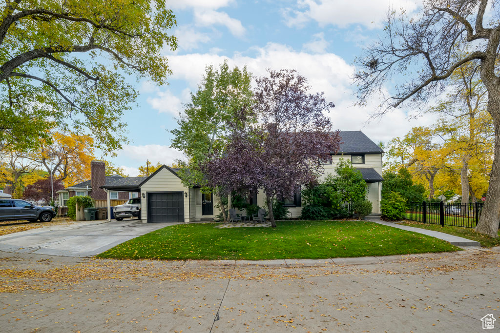 View of front facade featuring a garage and a front lawn