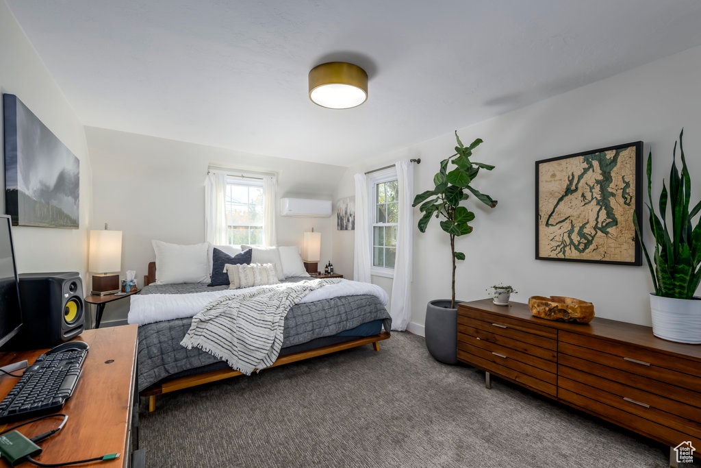 Carpeted bedroom featuring an AC wall unit