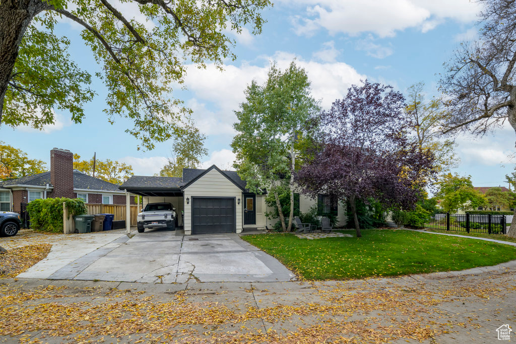 View of front of home with a front yard and a garage