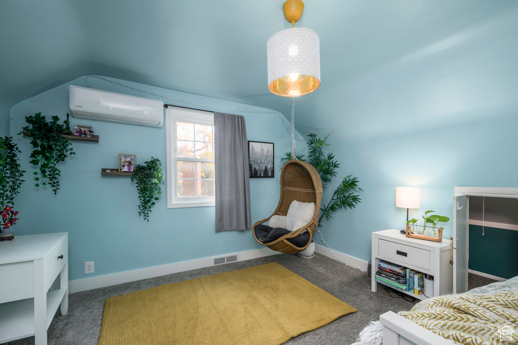 Carpeted bedroom with a wall unit AC and vaulted ceiling