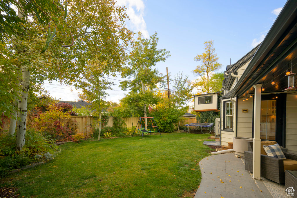 View of yard featuring a patio and a trampoline