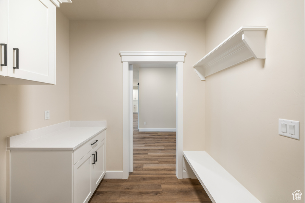 Mudroom featuring dark wood-style flooring and baseboards
