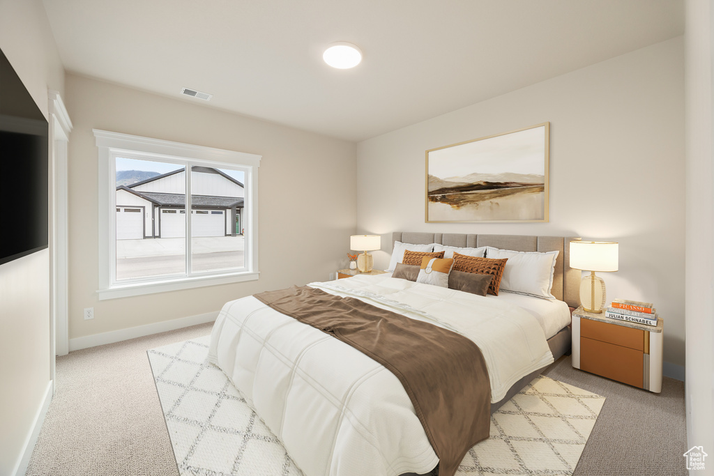 Bedroom featuring light carpet and baseboards