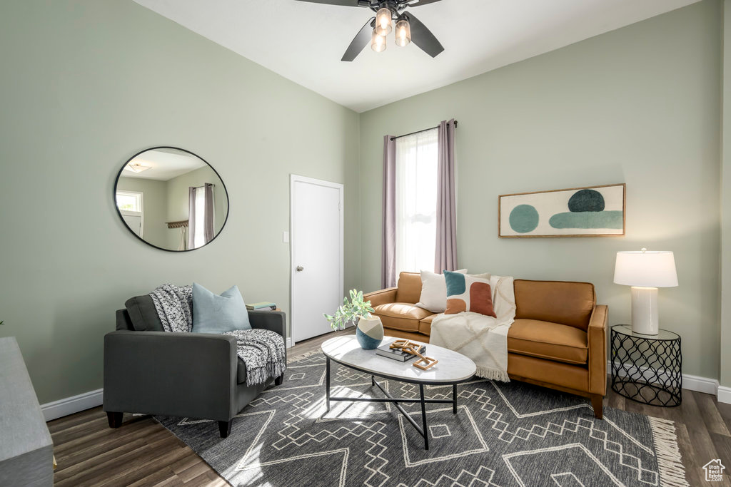 Living room with dark wood-type flooring, vaulted ceiling, and ceiling fan