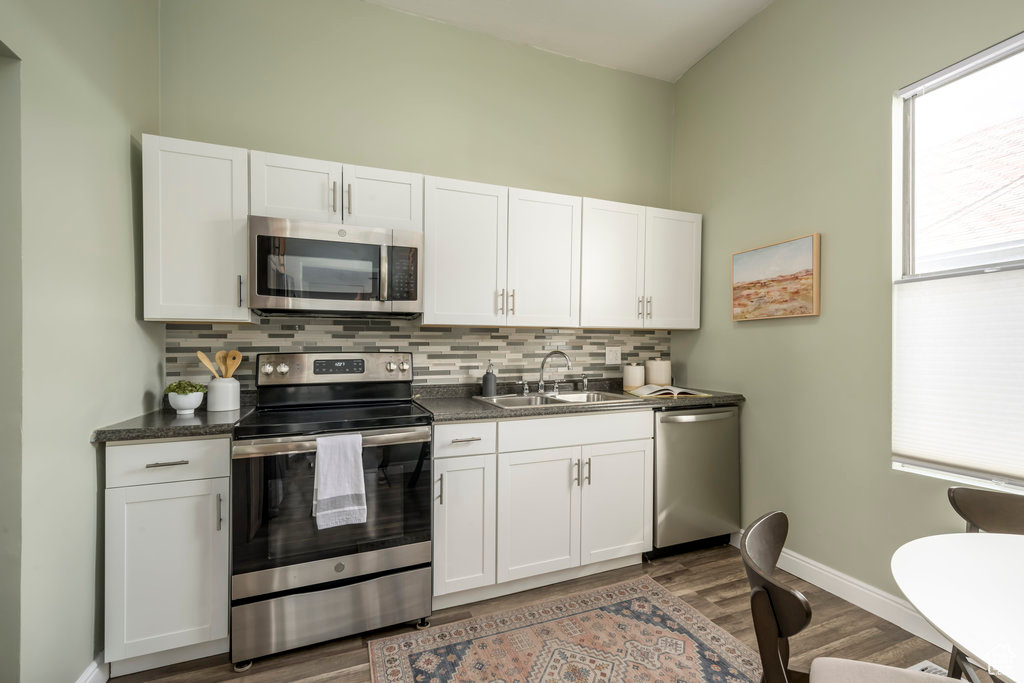 Kitchen featuring white cabinetry, appliances with stainless steel finishes, sink, and dark hardwood / wood-style floors